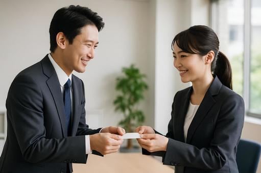 名刺交換する男女社員 名刺交換する男女社員の写真