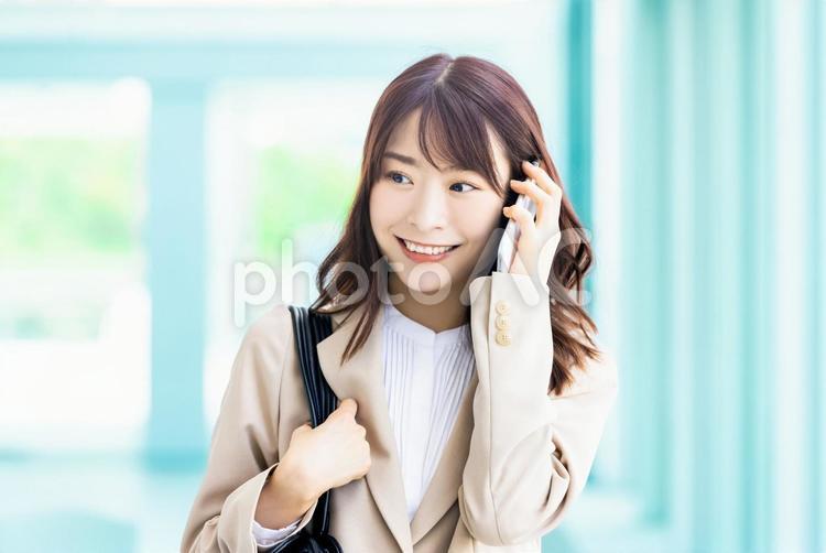 スマホで通話する笑顔のビジネスウーマン 女性,ビジネス,ビジネスウーマンの写真素材