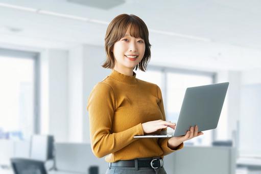パソコンを持つ女性・ビジネスウーマン 女性,パソコン,笑顔の写真素材