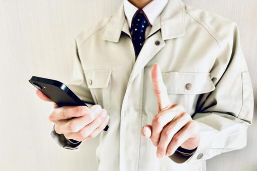 バインダーを持って人差し指を立てる作業員 スマホ,ポイント,注意の写真素材