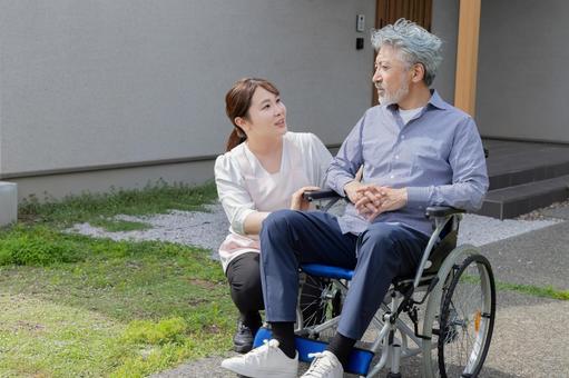 庭で車椅子に乗るシニア男性と介護士 庭で車椅子に乗るシニア男性と介護士 シニア,車椅子,散歩の写真素材