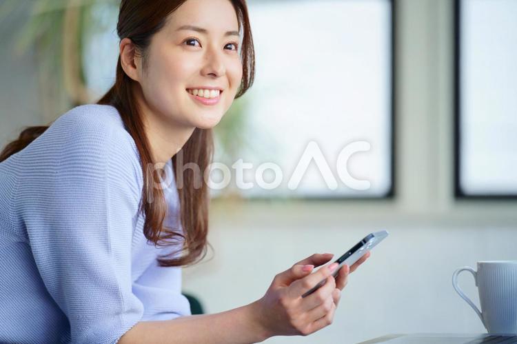 ソファーに座ってスマートフォンを使う女性 女性,日本人,1人の写真素材