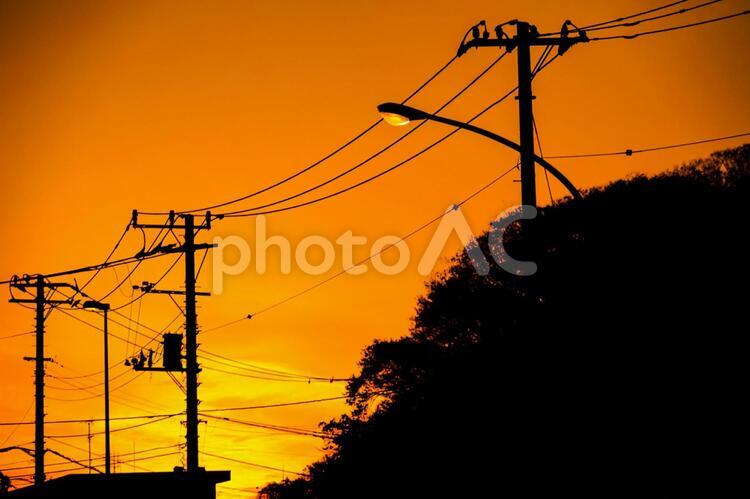 夕焼けと電線と建物のシルエット 電柱,電線,シルエットの写真素材