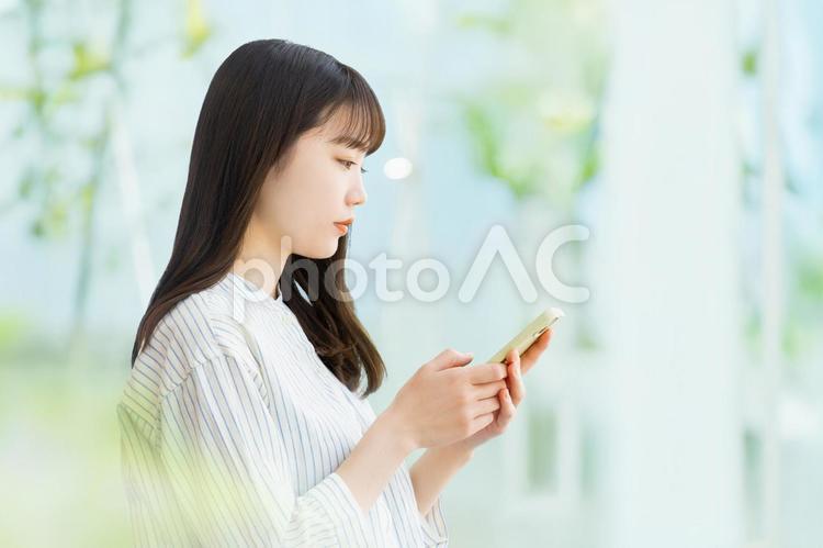 スマホを使う若い女性・ビジネスウーマン 女性,スマホ,スマートフォンの写真素材