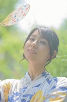 A woman wearing a yukata holding a fan, JPG