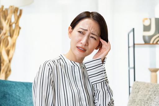 頭を抑える女性 女性,頭痛,片頭痛の写真素材