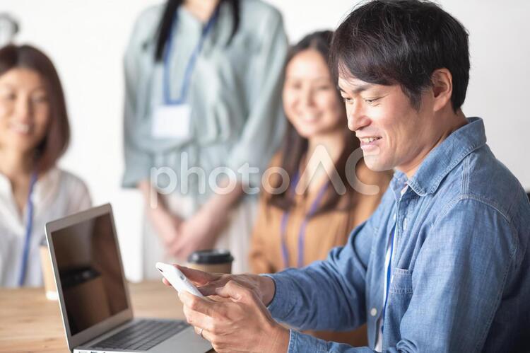 服装自由な会社でスマホを使う会社員 スマホ,ビジネス,スマートフォンの写真素材