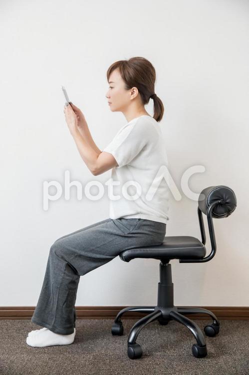 姿勢よくスマホを見る女性 スマホ,姿勢,良いの写真素材