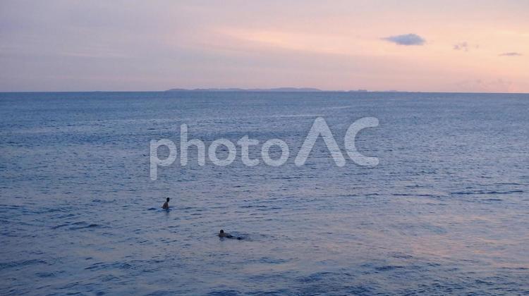 日が沈む頃の静かな海で友人と 海,海遊び,海に浮かぶ人の写真素材