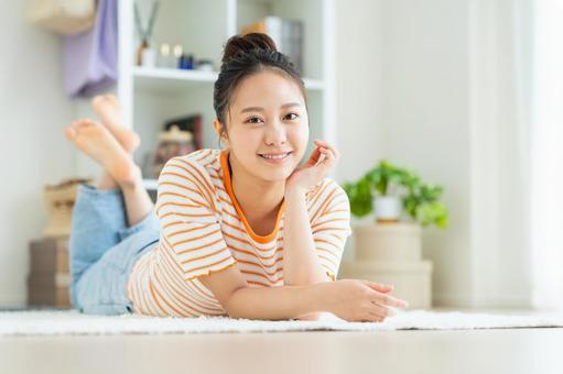 リビングでくつろぐ若い女性 リビングでくつろぐ若い女性の写真