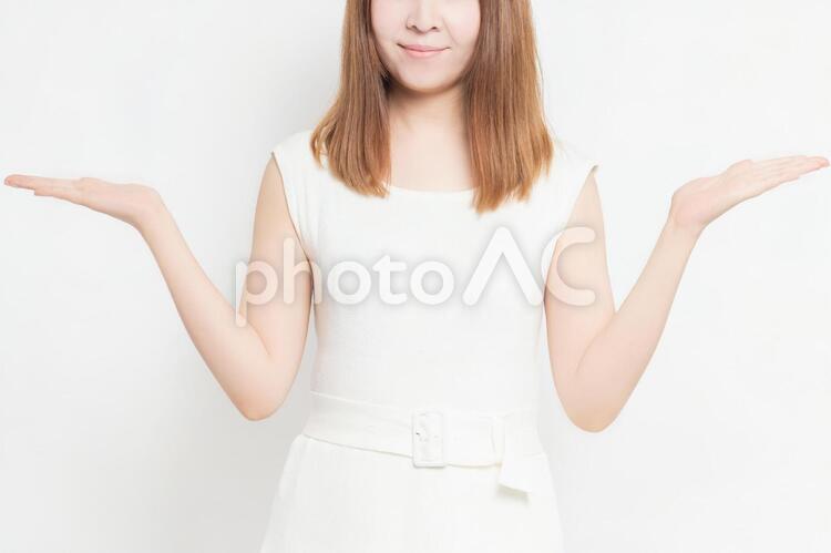 案内のジェスチャーをする若い女性 女性,案内,こちらの写真素材