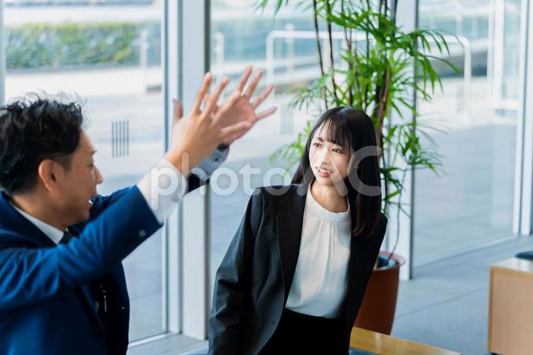 楽しそうに上司の話を聞くキャリアウーマン ビジネスウーマン,ビジネスマン,女性の写真素材