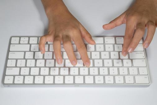 ワイヤレスキーボードでタイピングする手元 タイピング,キーボード,両手の写真素材
