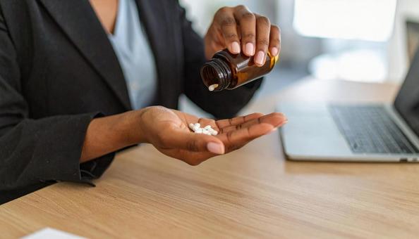 薬を手の平に乗せるビジネスウーマンの写真