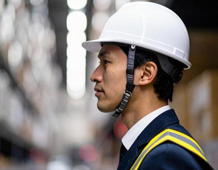 ヘルメットをかぶった作業服の男性の横顔 ヘルメットをかぶった作業服の男性の横顔の写真