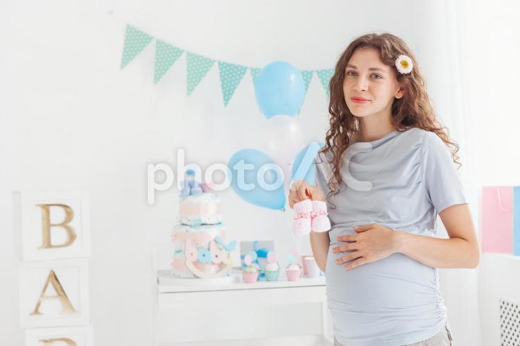 ベビーシューズを持って遠くを見る女性 女性,人物,風船の写真素材