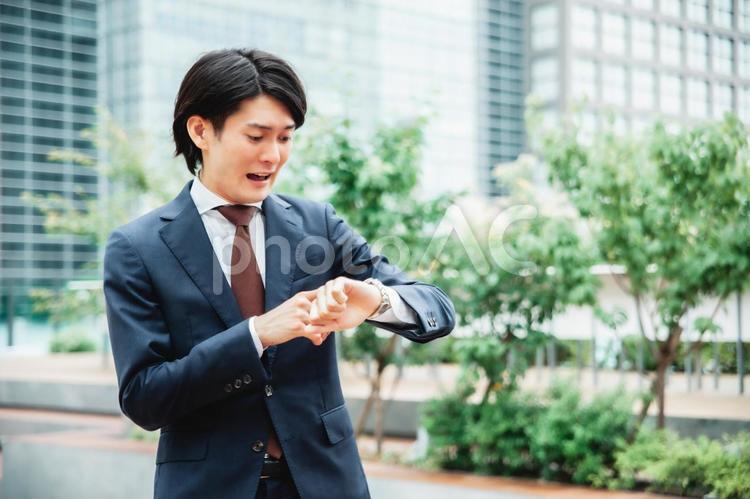 時計を見て焦るビジネスマン（遅刻） 遅刻,忙しい,締め切りの写真素材