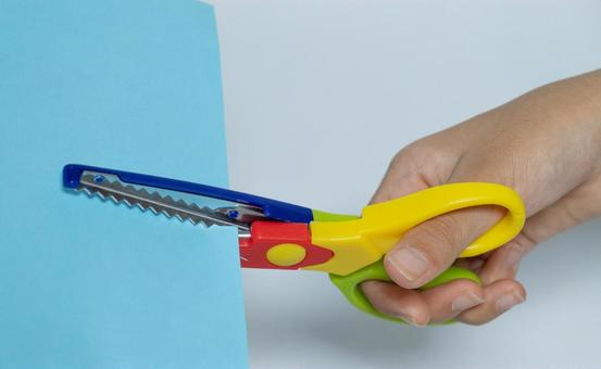 ギザギザバサミで青い紙を切る手 ギザギザ,はさみ,カットの写真素材