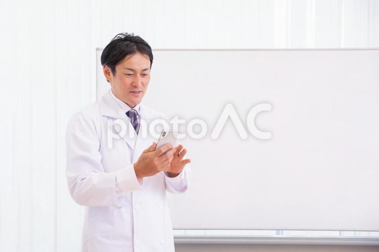 医者とホワイトボード（スマホ・アプリ・笑顔） 医者,医師,薬剤師の写真素材