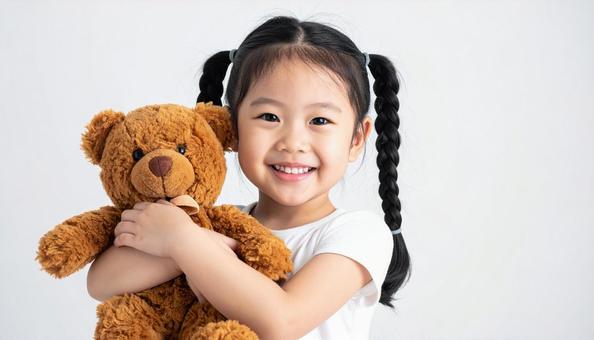お気に入りのクマのぬいぐるみを抱く子供 お気に入りのクマのぬいぐるみを抱く子供の写真