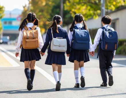 通学中の子供達の後ろ姿 通学中の子供達の後ろ姿の写真