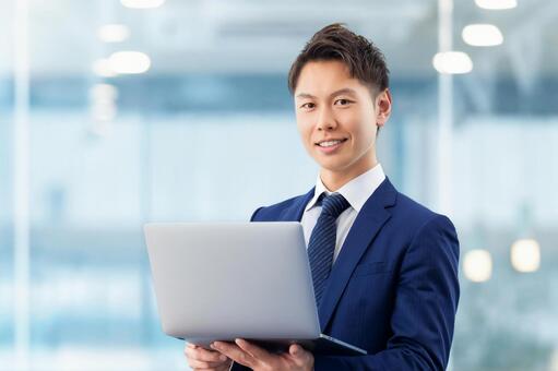 ノートパソコンを持つ男性ビジネスマン 男性,パソコン,ノートパソコンの写真素材