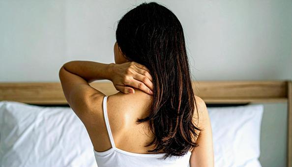 寝違えて首痛に苦しむ女性 寝違えて首痛に苦しむ女性の写真