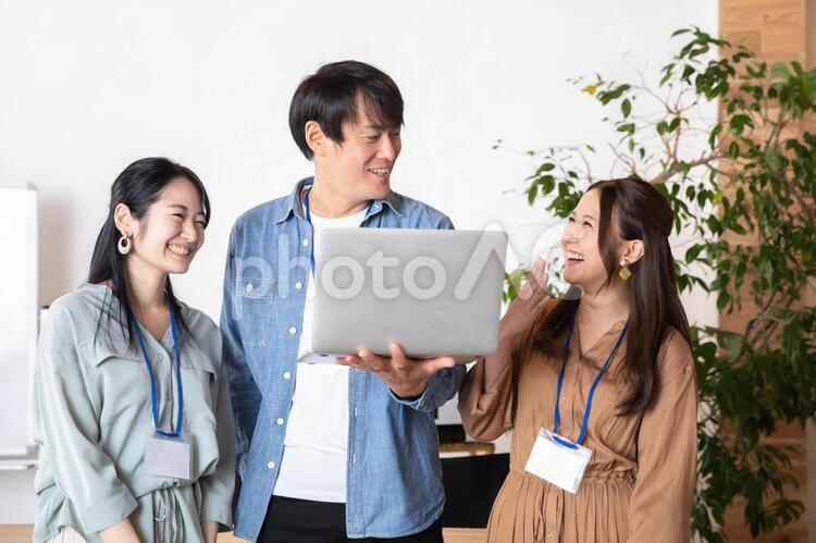 ノートパソコンをみる男女の会社員 デザイナー,エンジニア,システムエンジニアの写真素材