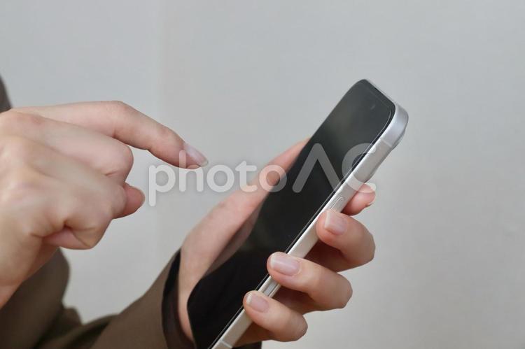 スマホを指さす女性 スマホ,女性,顔なしの写真素材