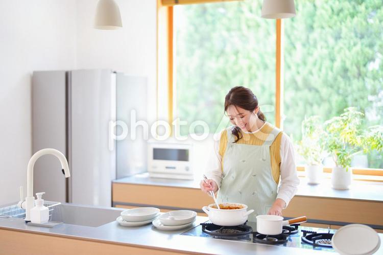 鍋のカレーを見つめる女性 女性,料理,母の写真素材