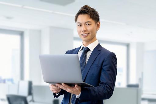 ノートパソコンを持つ男性ビジネスマン 男性,パソコン,ノートパソコンの写真素材