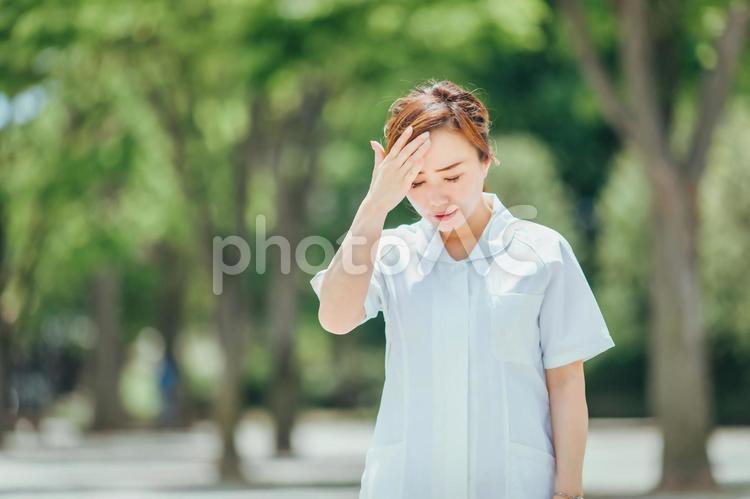 体調不良の白衣の女性 看護師,ナース,暑いの写真素材