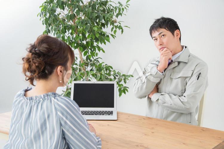 打ち合わせする作業着の男性（考える） 接客,女性,男性の写真素材