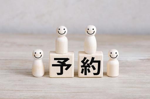 笑顔の人形と予約の文字ブロック 笑顔の人形と予約の文字ブロックの写真
