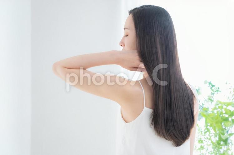 緑の中でヘアケアをする若い女性 ヘアケア,ビューティー,育毛の写真素材