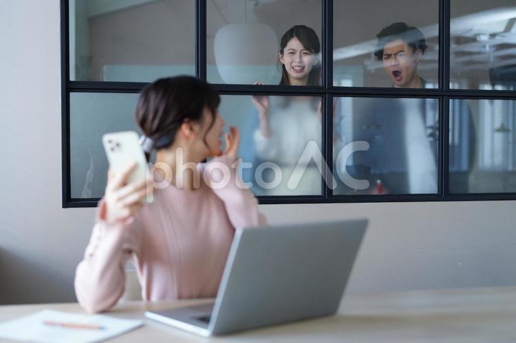 スマホを持ち振り向く女性と怒っている男女 男女,振り向く,見るの写真素材