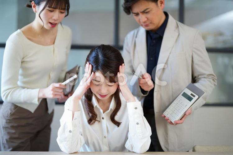 怒られているハーフアップの女性 男女,頭を抱える,困ったの写真素材
