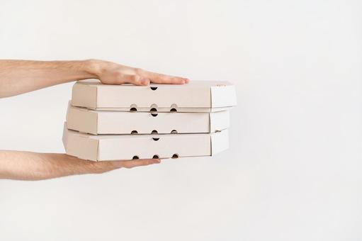 両手で3箱のピザ箱を差し出す 配達,フードデリバリー,テイクアウトの写真素材