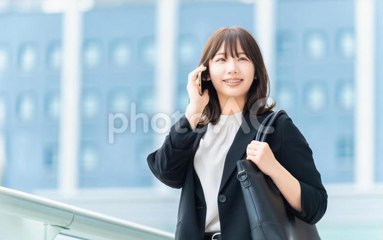 スマホで話す笑顔の女性・ビジネスウーマン 女性,スマホ,夏の写真素材