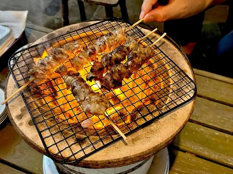 野外で七輪で炭火焼き鳥をしている人 野外で七輪で炭火焼き鳥をしている人の写真