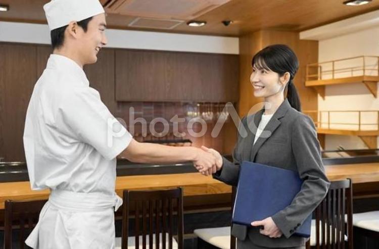 飲食店で握手をするビジネスウーマン 飲食店,握手,成約の写真素材