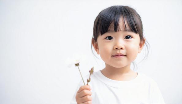 白い花を持つ子供の写真