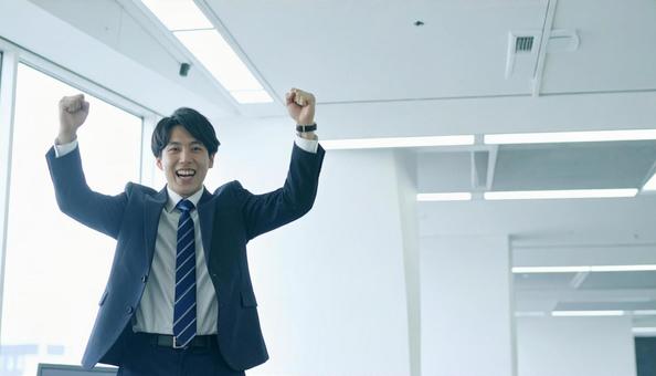 オフィスで喜ぶビジネスマン オフィスで喜ぶビジネスマンの写真
