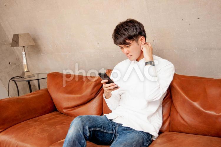 スマホを見て困る男性 スマホ,困る,悩むの写真素材