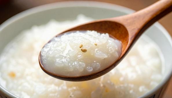 おかゆを木のさじですくう おかゆを木のさじですくうの写真