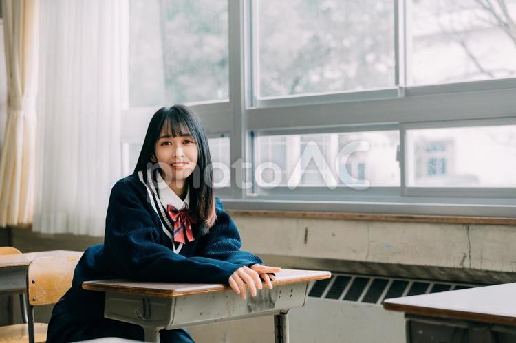 教室の机に座って見つめてくる女子高校生 女性,女子高,高校生の写真素材