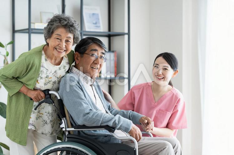 車椅子のシニアの夫婦と介護福祉士 介護,シニア,車椅子の写真素材