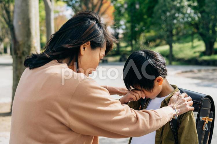 泣く小学生と心配する女性 いじめ,不登校,虐待の写真素材