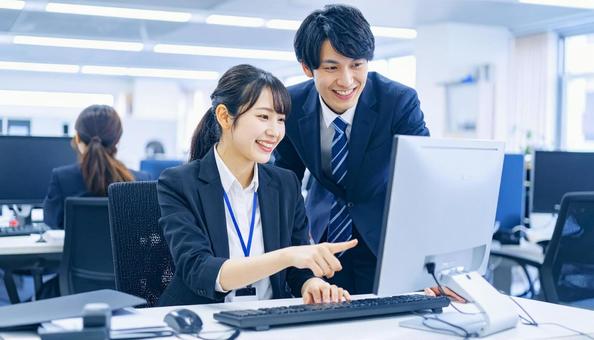 パソコンを見ながら打ち合わせをする社員 パソコンを見ながら打ち合わせをする社員の写真