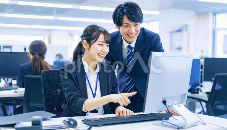 パソコンを見ながら打ち合わせをする社員 ビジネスマン,ビジネスウーマン,男女の写真素材